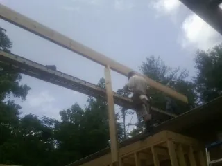 Carpenter setting a ridge beam over a new addition frame — Ice Dam Removal by Roofing Brothers in North Collins