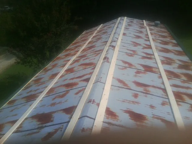 Rusted metal roof panels with new wood purlins before replacement — Storm Damage Roof Repair in North Collins by Roofing Brothers